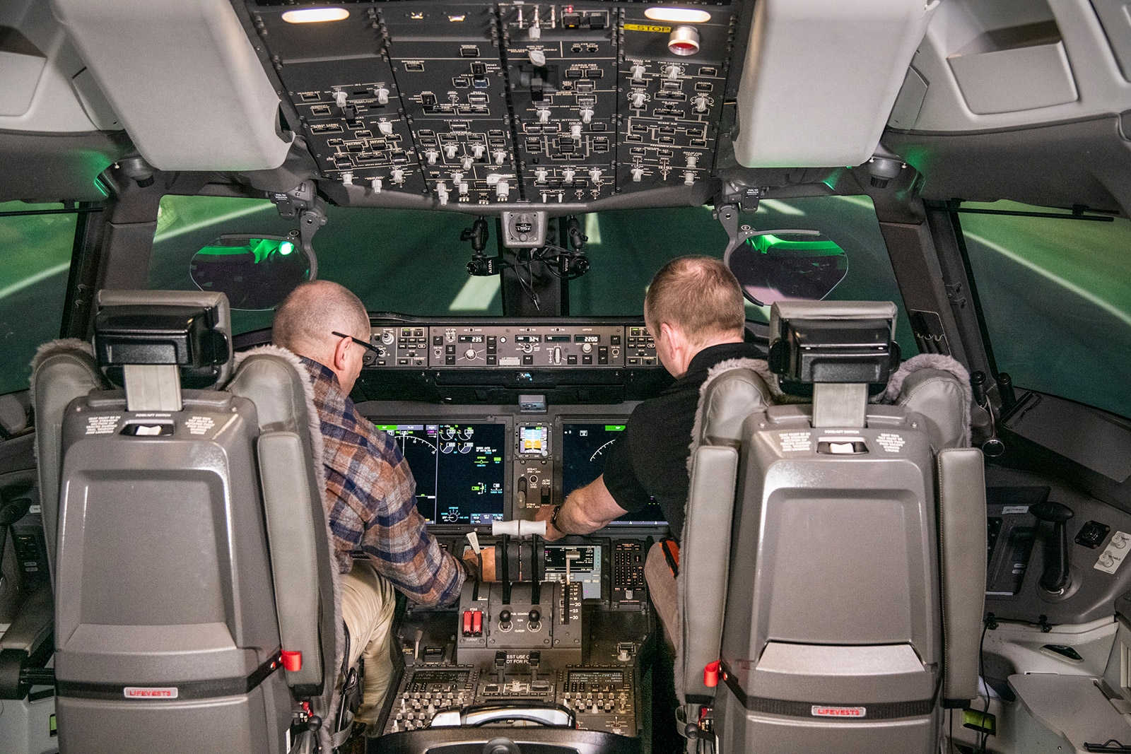 Capts. Gary Mandy (left), 777X chief technical pilot, and Tanner Sims, Engineering test pilot, develop operational scenarios presented to airline crews in the 777-9 simulator. (Marian Lockhart photo)
